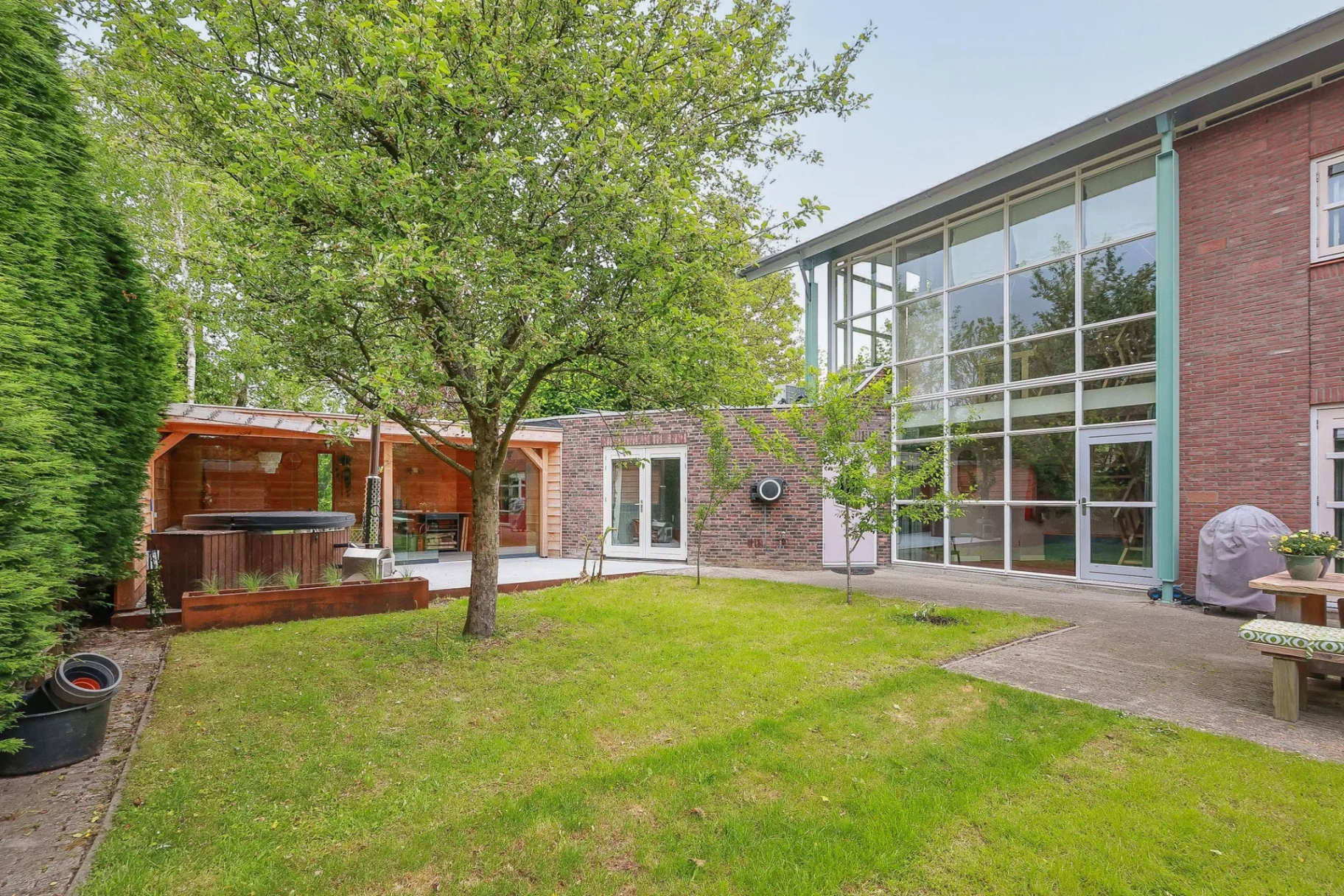 TWIXIT de achterzijde van de villa met tuin en grote glaspartij